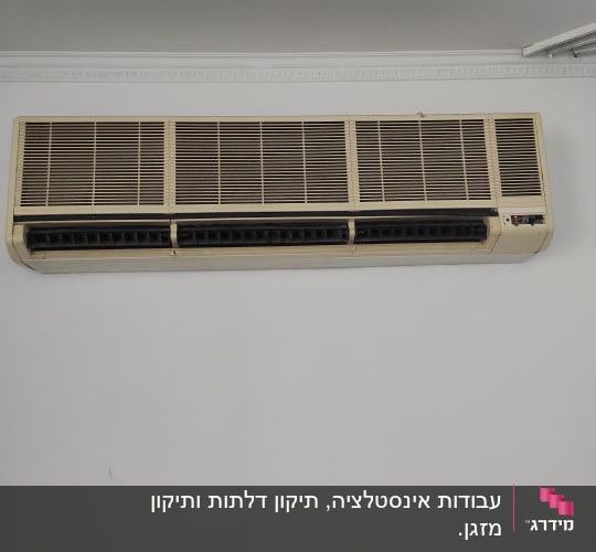 מזגן קיר ישן עם תריסים פתוחים